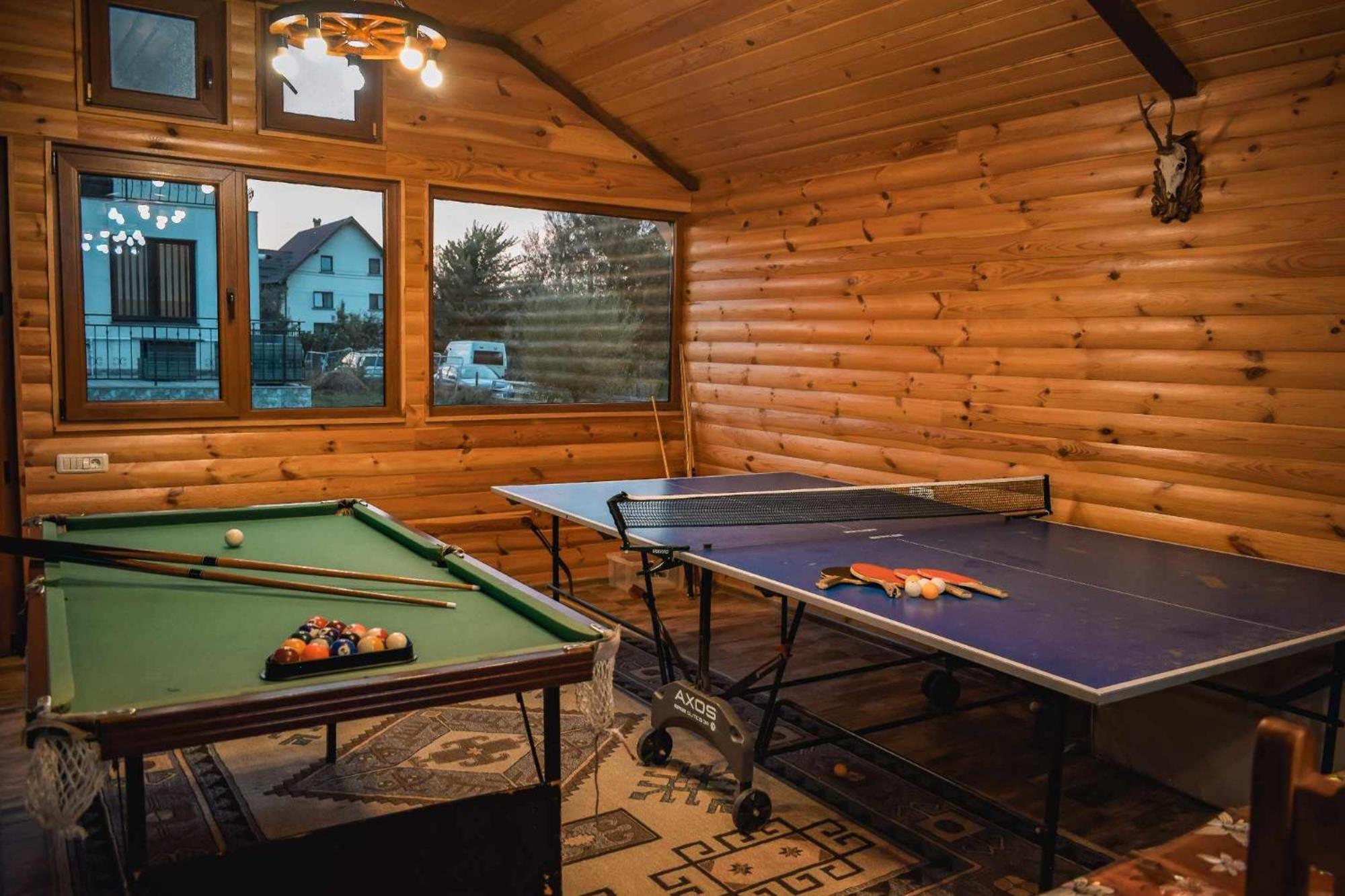 Masă de biliard și masă de ping-pong în camera din lemn
